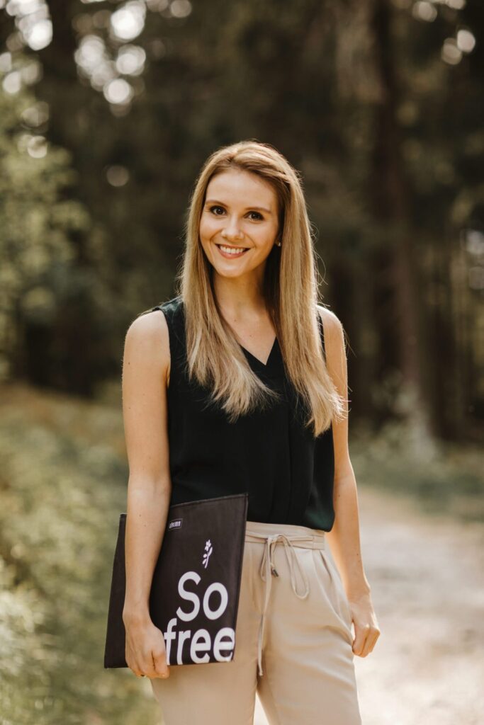 Lea, independent RINGANA partner, standing outdoors in a forest