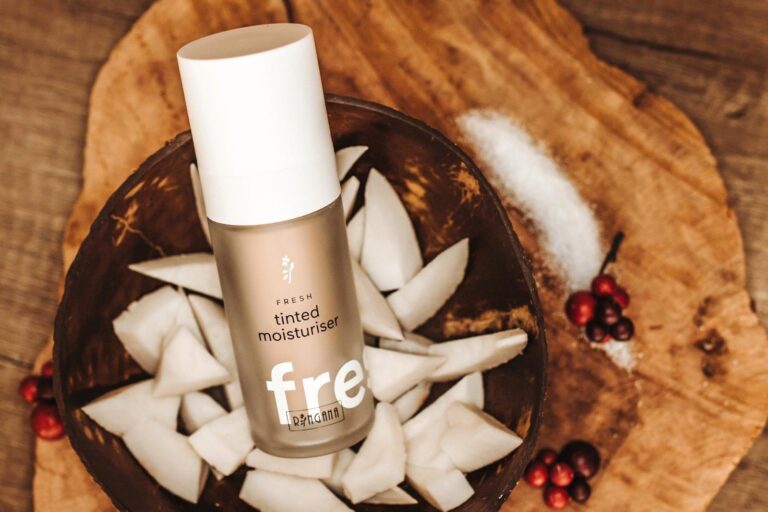 RINGANA Tinted Moisturizer on a wooden plate with coconut