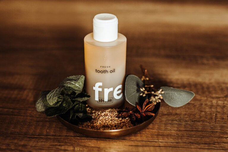 RINGANA Tooth Oil bottle with fresh herbs and spices