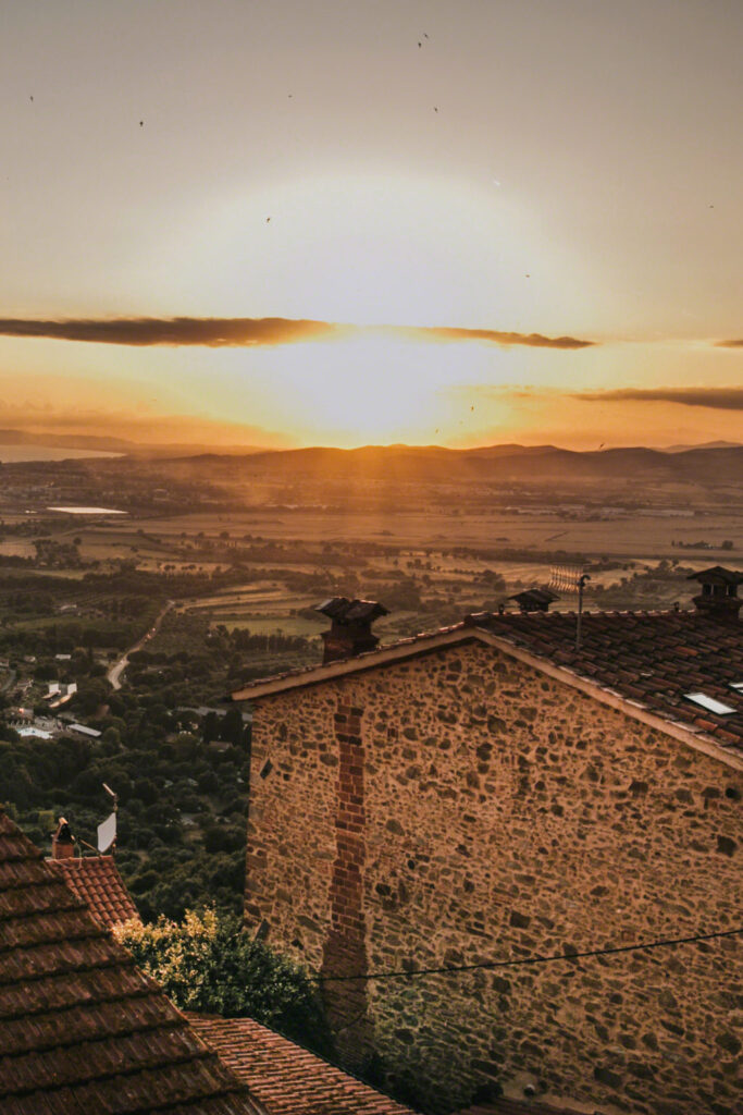 Golden sunset over rolling hills and an old stone house